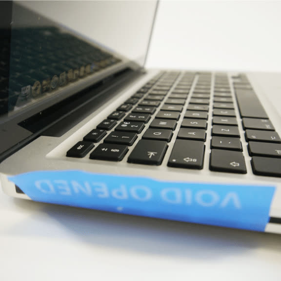 Non-residue tamper-evident security label sealing a laptop for IT asset protection