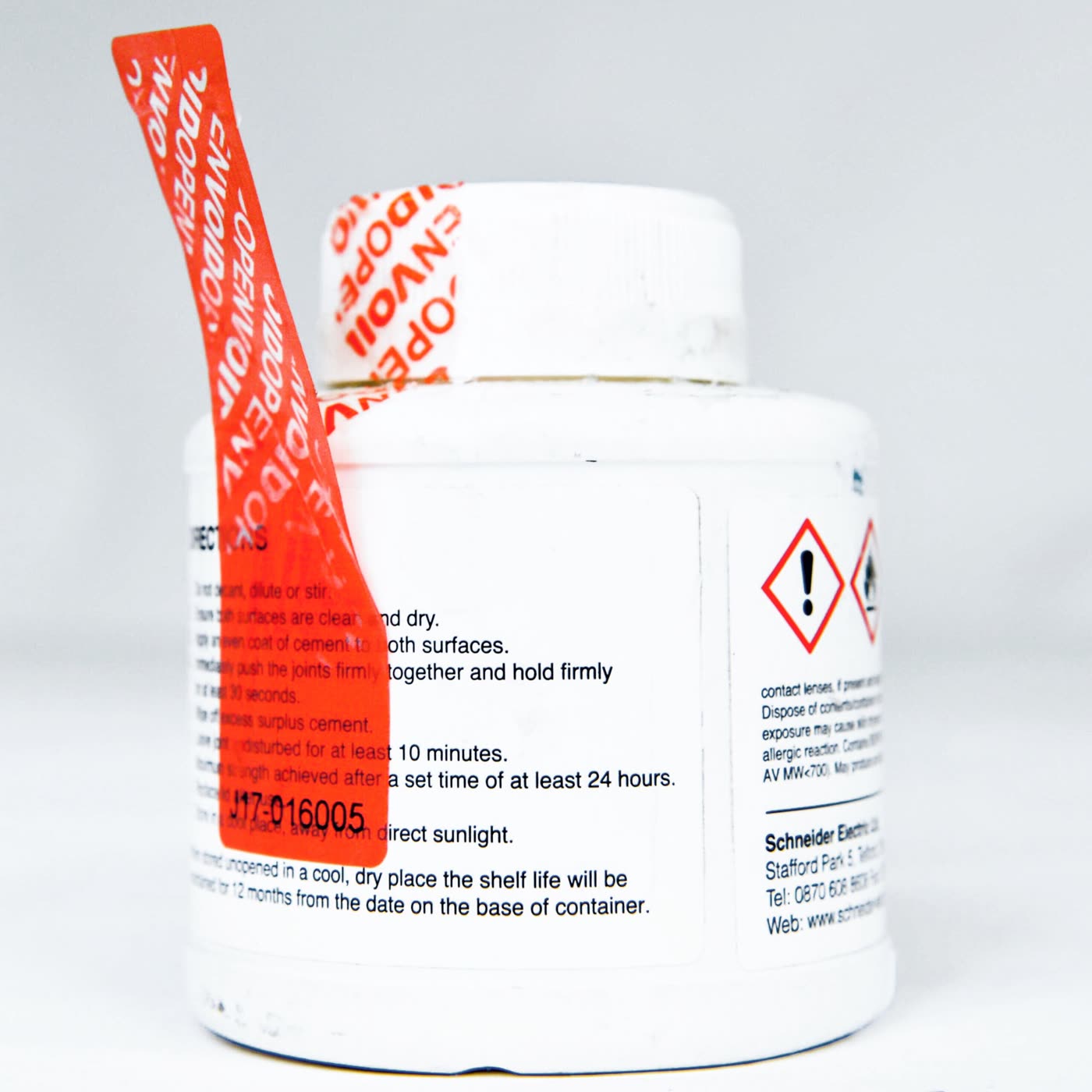 A red permanent tamper-evident security label lifted from a product container, showing repeating VOID OPEN evidence